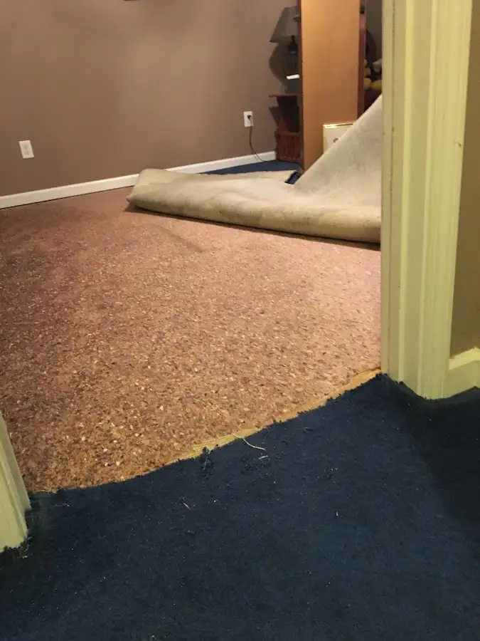 Carpet pad removal revealing water damage during Water Mitigation Services in North Caldwell